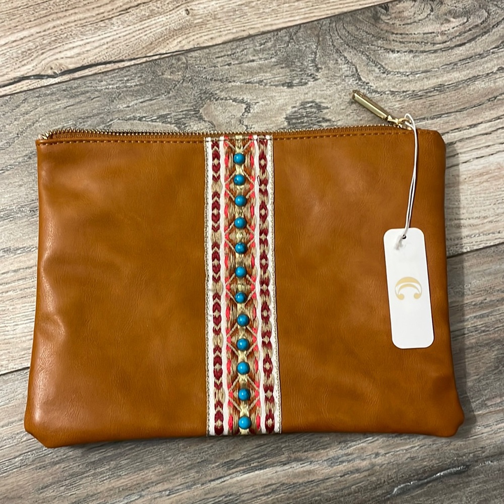 Brown leather cosmetic bag with Aztec/rustic type design on the front middle.